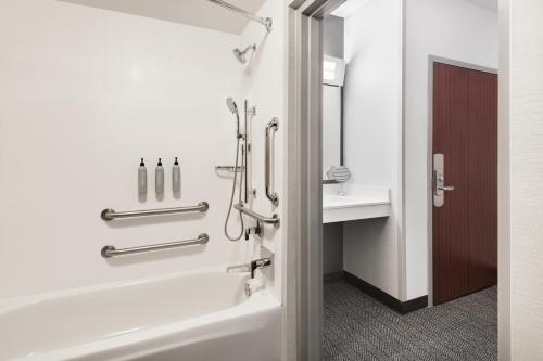 a bathroom with a bath tub and a sink at Courtyard by Marriott Burlington in Burlington