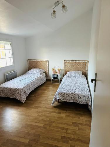Cette chambre blanche dispose de 2 lits et de parquet. dans l'établissement Les terrasses de la moine, à Cholet