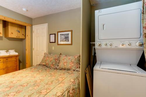 a small bedroom with a bed and a washer at Wawona Chalet in Wawona
