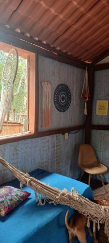 a room with a bed with a hammock in it at RECANTO DO SENTIR, conexão com a natureza e muita paz. in Praia do Forte