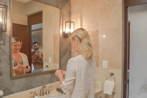 a woman standing in front of a bathroom mirror at Casa Lucia Hotel Boutique in Mérida