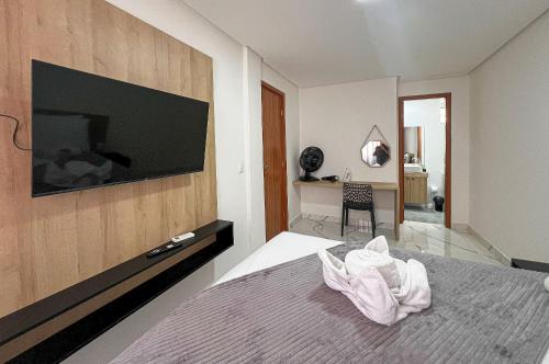 a bedroom with a bed with a television on the wall at Aconchegante Térreo Bessa 4 pessoas 200m da Praia in Nossa Senhora do Livramento