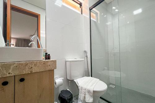 a bathroom with a toilet and a glass shower at Aconchegante Térreo Bessa 4 pessoas 200m da Praia in Nossa Senhora do Livramento