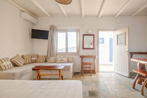 a living room with a couch and a table at Heliopetra Punta in Ios Chora