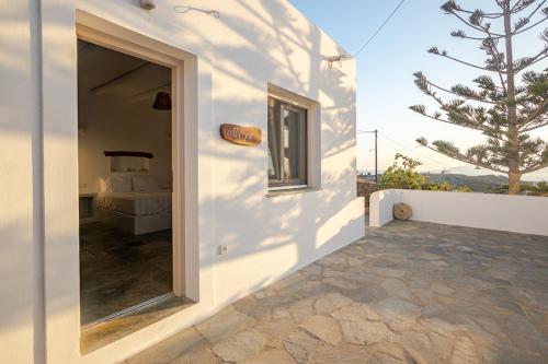 a white building with a door leading to a bedroom at Heliopetra Punta in Ios Chora