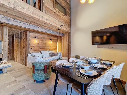 une salle à manger avec une table, des chaises et un canapé dans l'établissement Duplex lumineux rénové, pied des pistes, balcon - FR-1-344-252, à Saint-Martin-de-Belleville