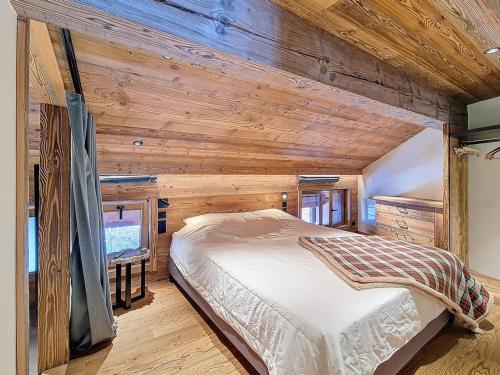 une chambre avec un lit dans un mur en bois dans l'établissement Duplex lumineux rénové, pied des pistes, balcon - FR-1-344-252, à Saint-Martin-de-Belleville