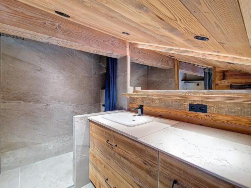 La salle de bains est pourvue d'un lavabo et d'un mur en bois. dans l'établissement Duplex lumineux rénové, pied des pistes, balcon - FR-1-344-252, à Saint-Martin-de-Belleville