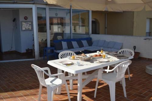 une table blanche et des chaises dans un salon dans l'établissement L'Ile Rousse UN beau T4 face aux îles, à LʼÎle-Rousse