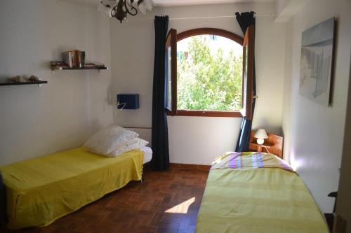 une chambre avec deux lits et une fenêtre dans l'établissement L'Ile Rousse UN beau T4 face aux îles, à LʼÎle-Rousse