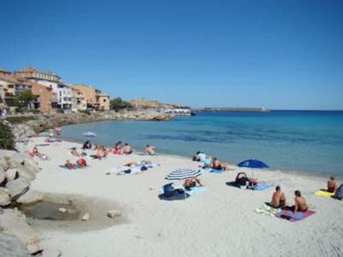 un groupe de personnes assises sur une plage dans l'établissement L'Ile Rousse UN beau T4 face aux îles, à LʼÎle-Rousse
