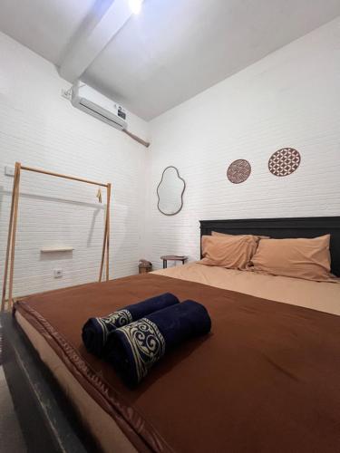 a bedroom with a large bed with a brown blanket at PaddyView by Zzz in Banyuwangi