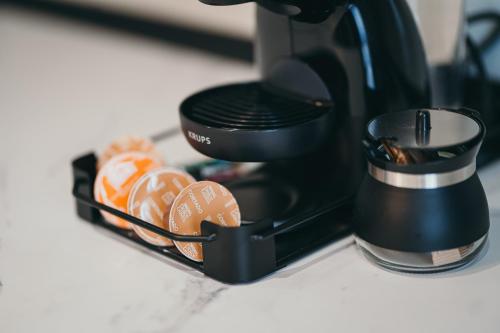 a black coffee maker sitting on a counter with food at Exclusiv Est One in Drobeta-Turnu Severin
