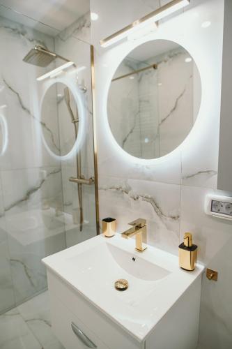 a white bathroom with a sink and a mirror at Exclusiv Est One in Drobeta-Turnu Severin