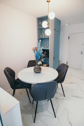 a dining room with a white table and chairs at Exclusiv Est One in Drobeta-Turnu Severin