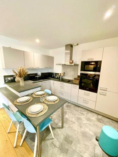 une cuisine avec une table et des chaises bleues. dans l'établissement Paisible appartement, à Marolles-en-Brie