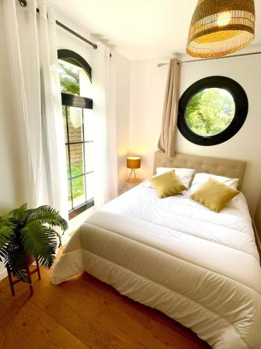 une chambre avec un lit blanc et une fenêtre dans l'établissement Paisible appartement, à Marolles-en-Brie