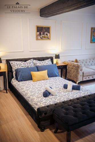 - une chambre dotée d'un grand lit avec des oreillers bleus et jaunes dans l'établissement Le Palais de Velours (Centre-Ville Historique), à Auxerre