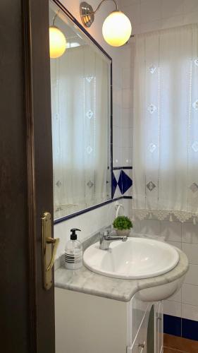 a bathroom with a white sink and a mirror at Apartamento El convento in Almodóvar del Río