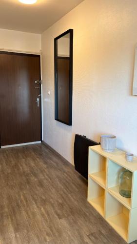 Cette chambre comprend une porte et une étagère avec un miroir. dans l'établissement LE POP appartement contemporain avec terrasse et parking, à Bonneville