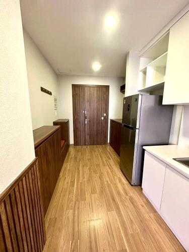 a kitchen with wooden floors and a kitchen with a refrigerator at Reply 1996 Apartment in DaLat Center in Da Lat
