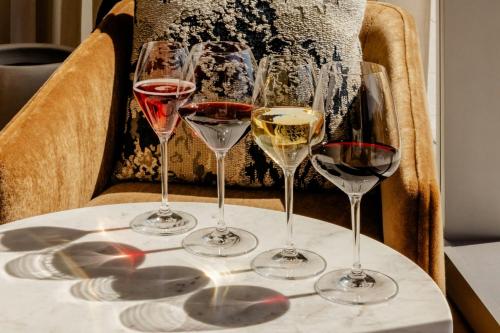 four glasses of wine sitting on a table at HALL Park Hotel, Autograph Collection in Frisco