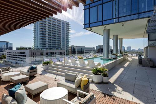 a rooftop patio with chairs and a pool on a building at HALL Park Hotel, Autograph Collection in Frisco