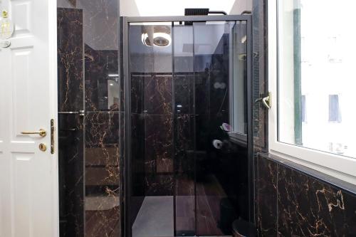 a shower with a glass door in a bathroom at Stella Polare Sensorial Home in Lido di Ostia