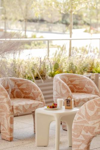 two chairs and a table with a cup of coffee at HALL Park Hotel, Autograph Collection in Frisco