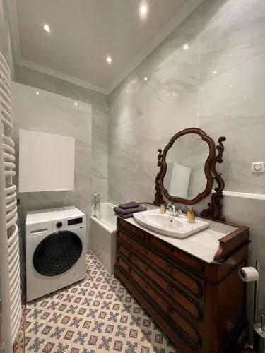 une salle de bain avec un lavabo et une machine à laver dans l'établissement L'Atrium Foch, à Paris