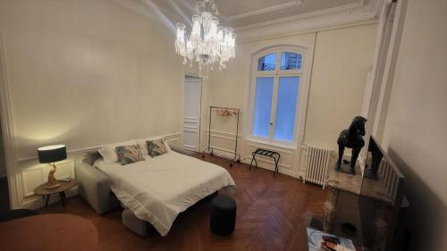 une chambre avec un lit et un lustre dans l'établissement L'Atrium Foch, à Paris