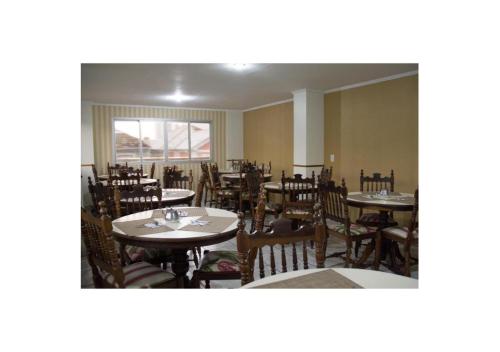 a dining room with tables and chairs and a window at Mariano Palace Hotel in Campinas