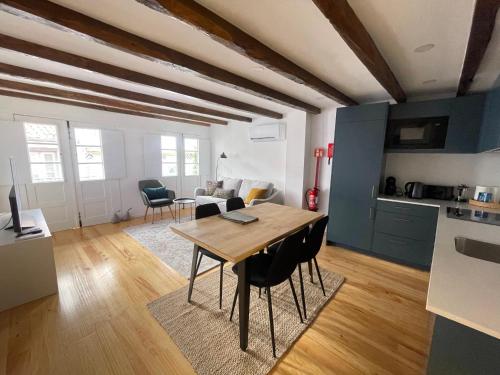 a kitchen and living room with a wooden table and chairs at Egas Duplex Historic Centre in Guimarães