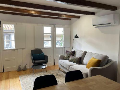 a living room with a couch and a table and chairs at Egas Duplex Historic Centre in Guimarães