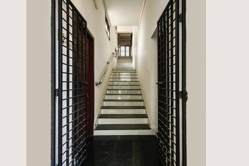 a hallway with stairs in a building with iron gates at Buraimi Apartments in Cochin