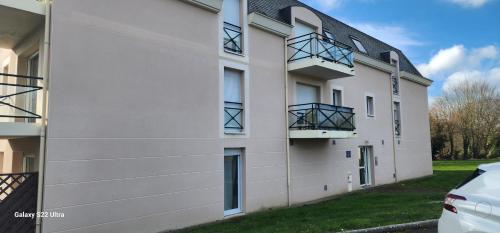 un bâtiment blanc avec des balcons sur le côté dans l'établissement Saint-A Loft, à Saint-Agathon