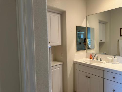 a bathroom with a sink and a mirror at Strawberry Fields Forever Oxnard Beauty in Oxnard