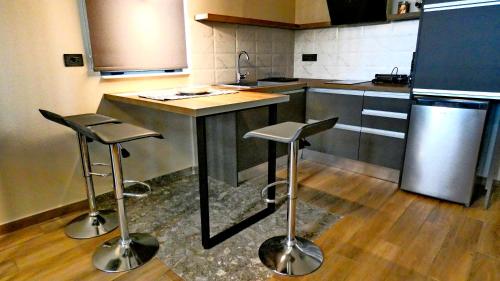 a kitchen with two stools and a island in a kitchen at GoldenRoyalSuites in Stalos