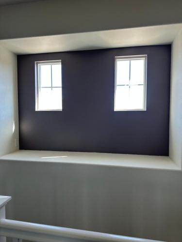 two windows on a blue wall in a room at Strawberry Fields Forever Oxnard Beauty in Oxnard