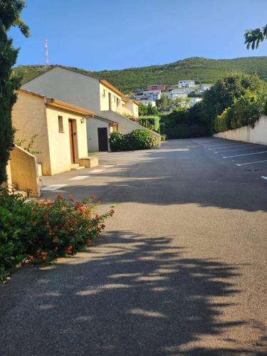 an empty parking lot with a building and some flowers at La Casa ISAIA, Cap Corse in Sisco