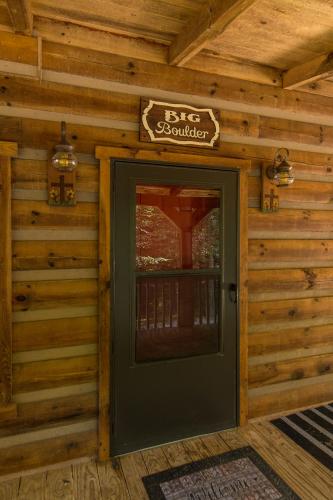 a door to a log cabin with a sign above it at Big Boulder Hot Tub Private Hiking in Rogers