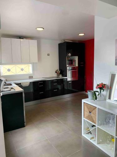 une cuisine avec des armoires et des appareils en noir et blanc dans l'établissement Villa bord de mer au Grau d 'Agde 140 m2, au Grau-dʼAgde