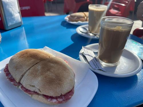 een broodje op een bord op een tafel met een drankje bij B&B Carmelina & Frasquito in Fuente de Piedra
