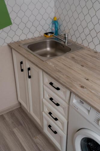 a kitchen counter with a sink and a washing machine at Махаббат in Petropavlovsk