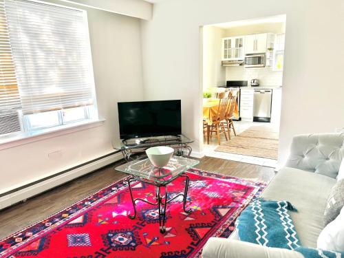 a living room with a couch and a table at Elegant Brand New Apartment in Central Burlington in Burlington