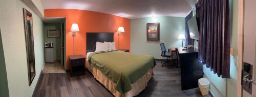 a small hotel room with a bed and a desk at Town & Country Motel in Sioux City