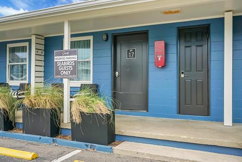 a blue house with a sign in front of it at Seabirds Motel At Kure Beach in Kure Beach