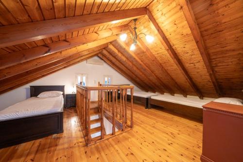 a attic room with two beds and a staircase at Lemonia Apartments Kefalonia in Andipáta Erísou
