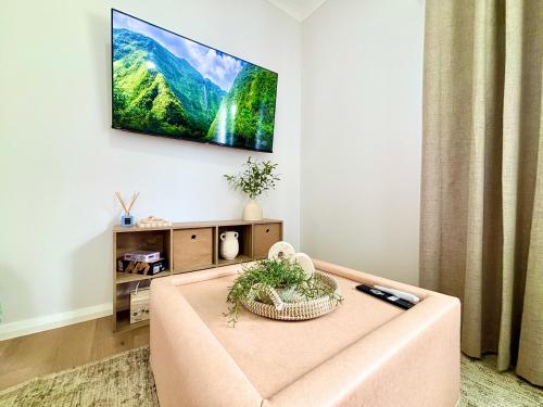 a living room with a couch and a tv on the wall at Joondalup Hidden Villa Gemma W Pool! in Perth