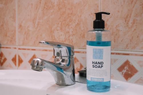 a bottle of hand soap sitting on a bathroom sink at Diáfano y acogedor en Vigo by CABANA Rentals in Vigo